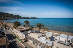 a view of a beach with palm trees and the ocean at Caravel Apartments Stalis in Stalida