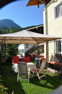un tavolo e sedie sotto un ombrellone bianco di Ferienwohnung Haus Datz in Berchtesgaden a Berchtesgaden