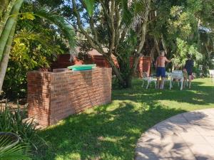 two people standing in a yard with a frisbee on a brick wall at House Elizabeth in Scottburgh
