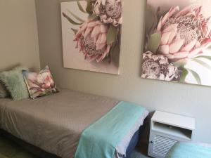 a bedroom with a bed and two pictures on the wall at House Elizabeth in Scottburgh