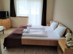 a bedroom with a large bed with towels on it at Pension Tilly in Niederöblarn