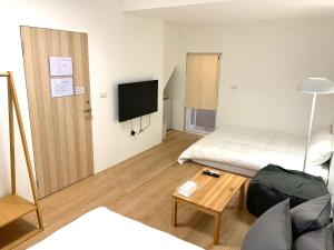 a hotel room with a bed and a tv at 小巷旺宅 X 旺福 in Tainan