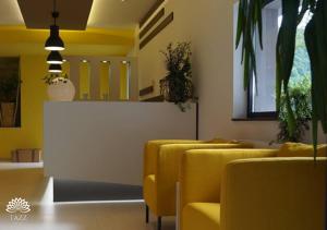 a row of yellow chairs in a waiting room at Hotel Tazz - River Front Oasis Collection in Bihać