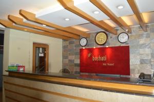 库克斯巴扎巴莎提湾度假酒店的餐厅的墙上挂有时钟的酒吧