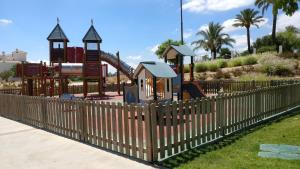 a wooden fence with a playground in a park at Calle Atlantico 108 1b Appartement in Sucina