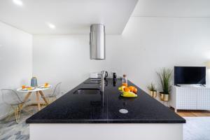 a kitchen with a black counter top with fruit on it at WHome | Alcântara Premium Studio in Lisbon +10 photos