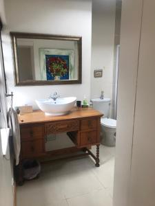 Un baño con lavabo, espejo e inodoro. en Seaview Place Bed and Breakfast, en East London