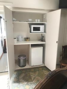 Una pequeña cocina con microondas y nevera. en Seaview Place Bed and Breakfast, en East London