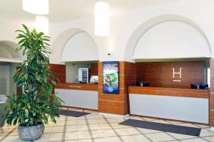 a restaurant with a cash counter and a palm tree at Hestia Hotel Ilmarine in Tallinn