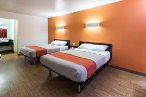 two beds in a room with orange walls at Motel 6-Stephenville, TX in Stephenville +23 photos