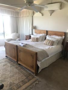 - une chambre avec un grand lit en bois et des oreillers blancs dans l'établissement Seaview Place Bed and Breakfast, à East London