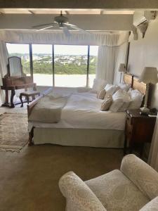 a bedroom with a large bed with a chair and a piano at Seaview Place Bed and Breakfast in East London