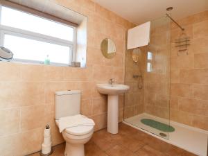 a bathroom with a toilet and a sink and a shower at Zoey Cottage in Skipton +20 photos