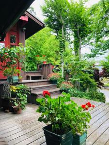 eine Veranda mit Blumen und Pflanzen auf einem Haus in der Unterkunft ガーデンハウス Mako Land in Toyama