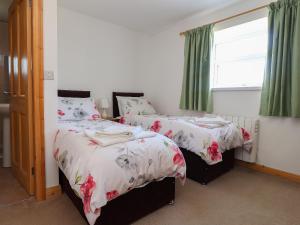 ein Schlafzimmer mit zwei Betten und einem Fenster in der Unterkunft Katy's Cottage in Skipton
