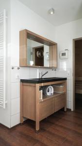 cocina con fregadero y espejo en Ferienhaus direkt am See - Kamin, Klima, Sauna und Boot, en Friedland