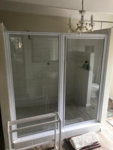 a shower with a glass door in a bathroom at Seaview Place Bed and Breakfast in East London