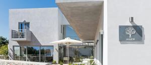 - un bâtiment blanc avec un parasol et un restaurant dans l'établissement Lidea Boutique Hotel, à Potamós