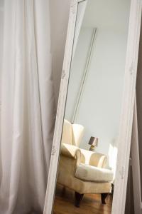 a mirror reflection of a chair in front of a window at Alsos Family Apartment in Corfu
