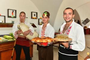 a group of three men holding plates of food at Hotel Elitsa in Albena