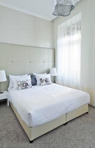 a bed room with a white bedspread and white pillows at Adele Boutique Hotel in Pécs