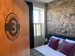 a bedroom with a bed with a sign on the wall at The Balerno Inn in Edinburgh