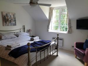 a bedroom with a bed and a window and a couch at The Retreat in Redlynch