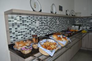 a kitchen counter filled with lots of different types of food at Hotel La Ville in Sousa