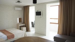 a hotel room with a bed and a table and a window at apart-hotel Sky in Yuzhne