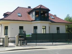 a large white house with a balcony and a fence at Kaitzbach-Idylle in Dresden