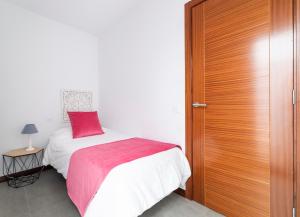 - une chambre avec un lit et une porte en bois dans l'établissement El Baladero, à Telde