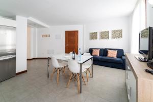 a living room with a table and a blue couch at El Baladero in Telde