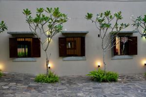 un edificio con ventanas y árboles delante de él en The Aluthgama House, en Aluthgama