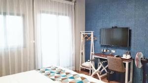 台東市的住宿－蘑菇30民宿，一间卧室配有一张床、一台电视和一张书桌