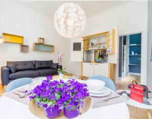 - un salon avec une table ornée de fleurs violettes dans l'établissement Grand Place Studio, à Bruxelles