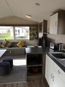 an rv kitchen with a sink and a couch at lakeland leisure park in Flookburgh