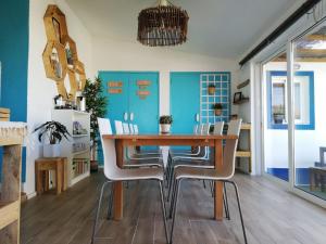 a dining room with a wooden table and white chairs at International Surf School & Camp in Sagres