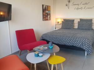sypialnia z łóżkiem, 2 krzesłami i stołem w obiekcie LE GARDEN CENTRAL STUDIO w mieście Dinan