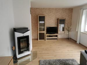 ein Wohnzimmer mit einem Kamin und einem TV in der Unterkunft Ferienwohnung Olympia Axams in Innsbruck