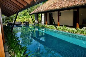 a swimming pool in front of a house at The Aluthgama House by TSC in Aluthgama