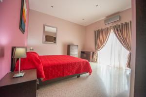 1 dormitorio con cama roja y ventana grande en Vittoriosa Seafront Highly Furnished Apartment FL 4, en Birgu