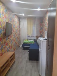 ニジニ・ノヴゴロドにあるApartamienty na Rozhdiestvienskoiのベッド2台とテレビが備わる小さな客室です。