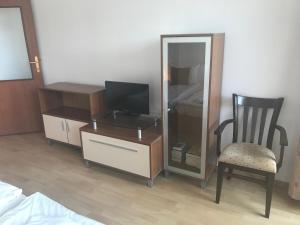 ein Schlafzimmer mit einer Kommode, einem Spiegel und einem Stuhl in der Unterkunft Flora Apartment 619 in Borowez