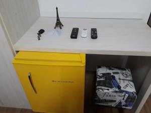 a desk with a yellow trash can and remote controls at Paris Residencial in Lagoa Santa