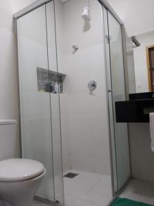 a bathroom with a shower with a toilet and a sink at Paris Residencial in Lagoa Santa