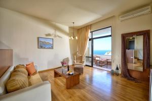 a living room with a couch and a table at Athina Palace Resort & Spa in Agia Pelagia