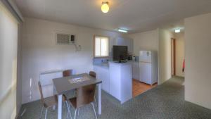 a small kitchen with a table and a refrigerator at Airport Tourist Village Melbourne in Melbourne