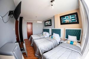 a room with two beds and a tv at Costa Del Inka Hotel in Urbanizacion Buenos Aires