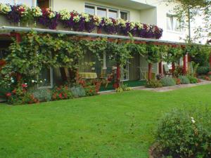 Una casa con flores al costado. en Pension Irene Nist, en Bad Birnbach
