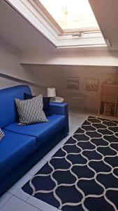 a living room with a blue couch and a rug at Attico mansardato davanti Casinò in Sanremo